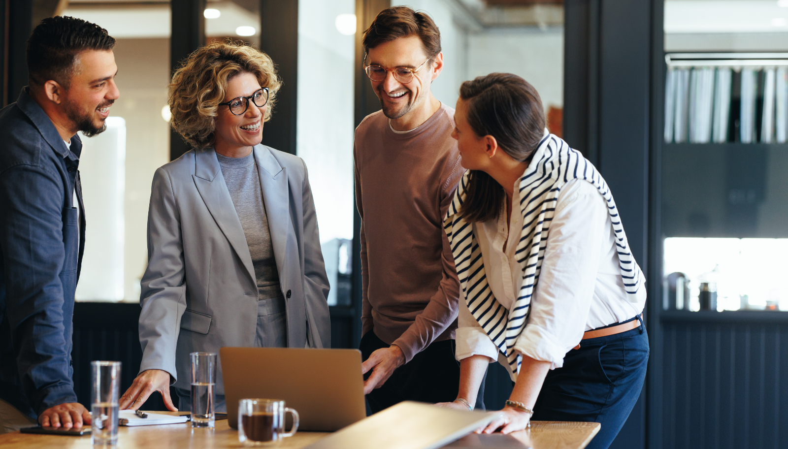 Sales team comparing notes around a laptop after a conference day